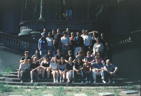 Eine Gruppe von Menschen sitzt und steht auf Treppen vor einem großen Gebäude. Alle blicken in die Kamera.  © privat