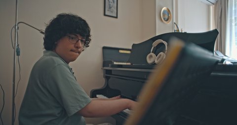 Eine Person spielt Klavier in einem Raum mit Kopfhörern auf dem Instrument. Die Atmosphäre wirkt kreativ und entspannt.  © Jasper Techel